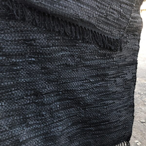 Melns paklājs ar bārkstīm.