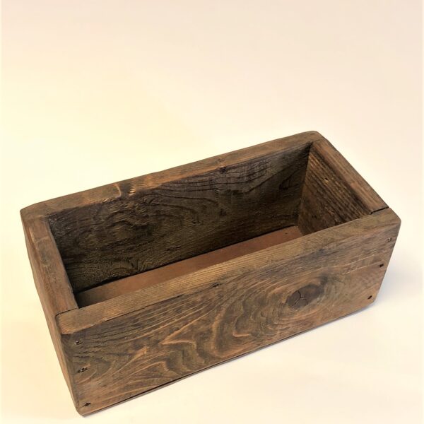 Tumši brūna koka kaste.