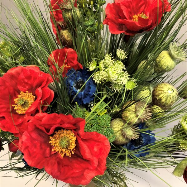 Līgo pušķis ar dažādiem ziediem un zaļumiem.