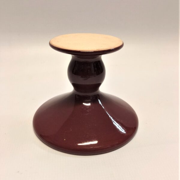 Sarkans keramikas svečturis.