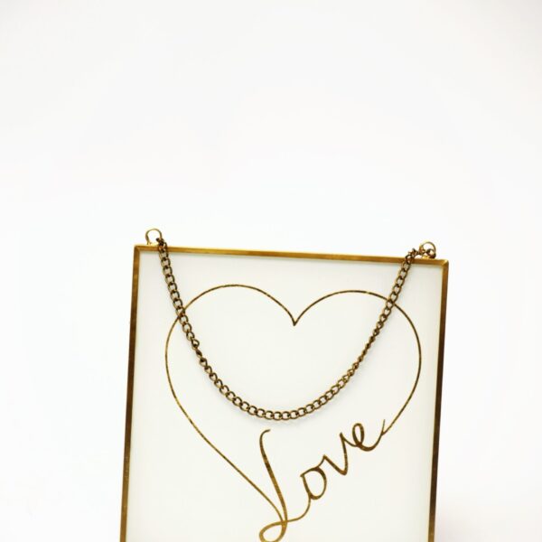 Iekarināms dekors ar uzrakstu LOVE zelta krāsā.