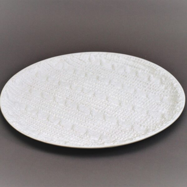 Balts škīvis ar adījuma rakstu.